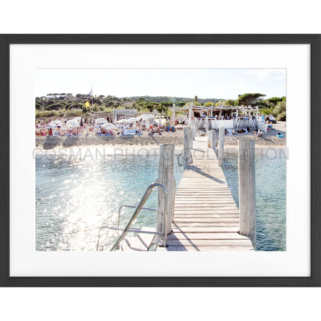 Holzsteg, der über kristallklares türkisfarbenes Wasser in Saint Tropez führt