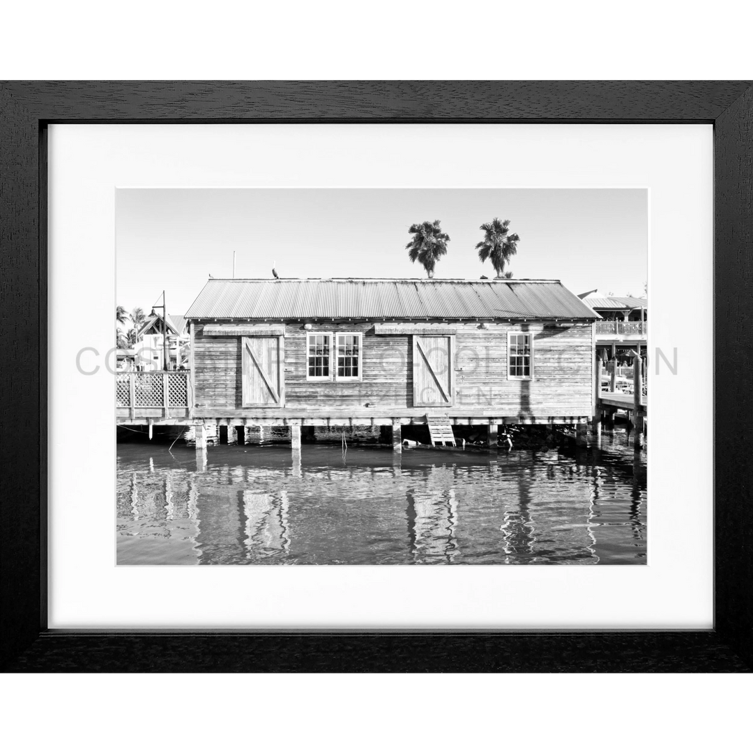 Schwarz-weiß gerahmtes Foto eines Wasserhauses auf Pfählen in Florida Key West