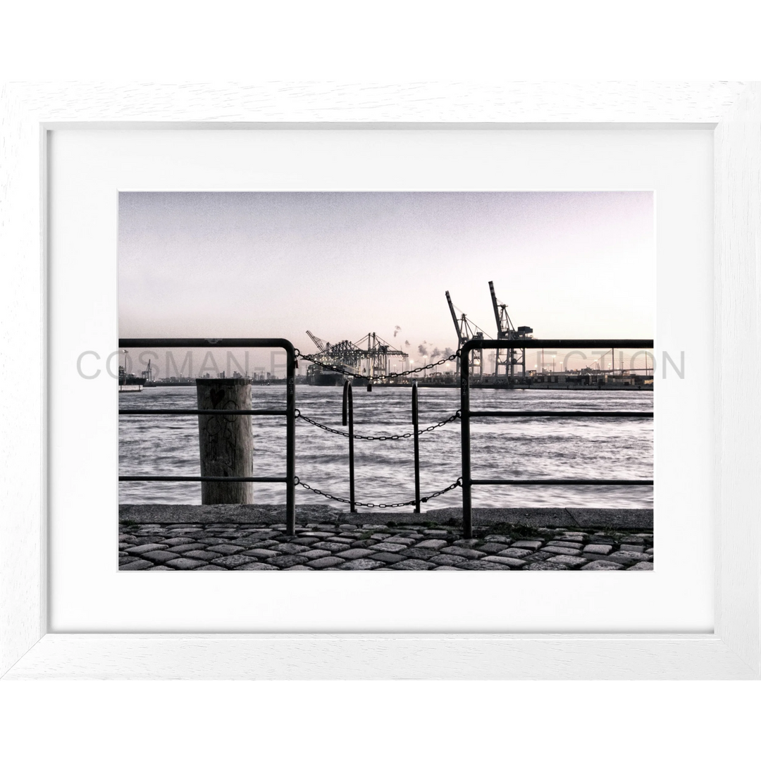 Gerahmtes Schwarz-Weiß-Foto von einem Hafen mit Krannen und Geländern