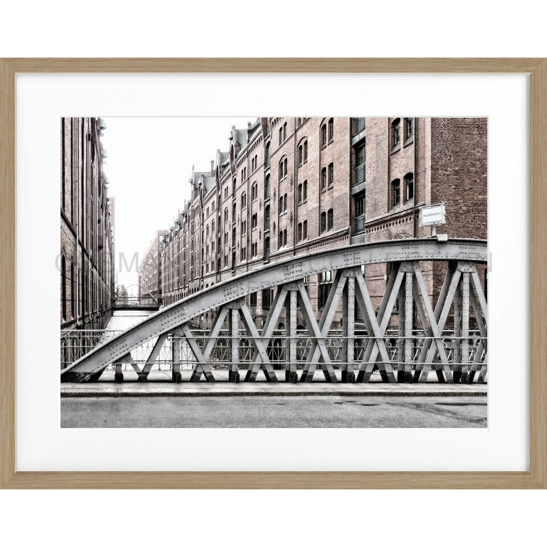 Schwarz-weißes Architekturphoto einer gebogenen Stahlbrücke in Hamburg Speicherstadt