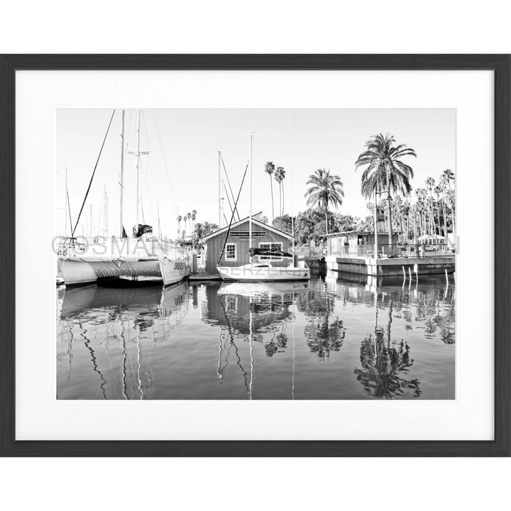 Schwarz-Weiß-Fotografie von Booten und einem Bootshaus im ruhigen Hafen von Santa Barbara