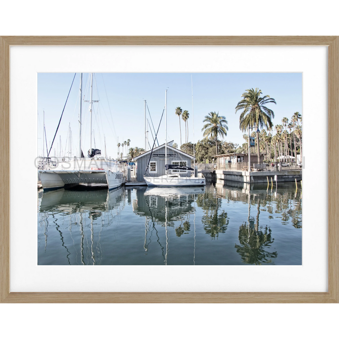 Rahmenfoto von Booten und einem Bootshaus mit Spiegelungen im Marina Wasser