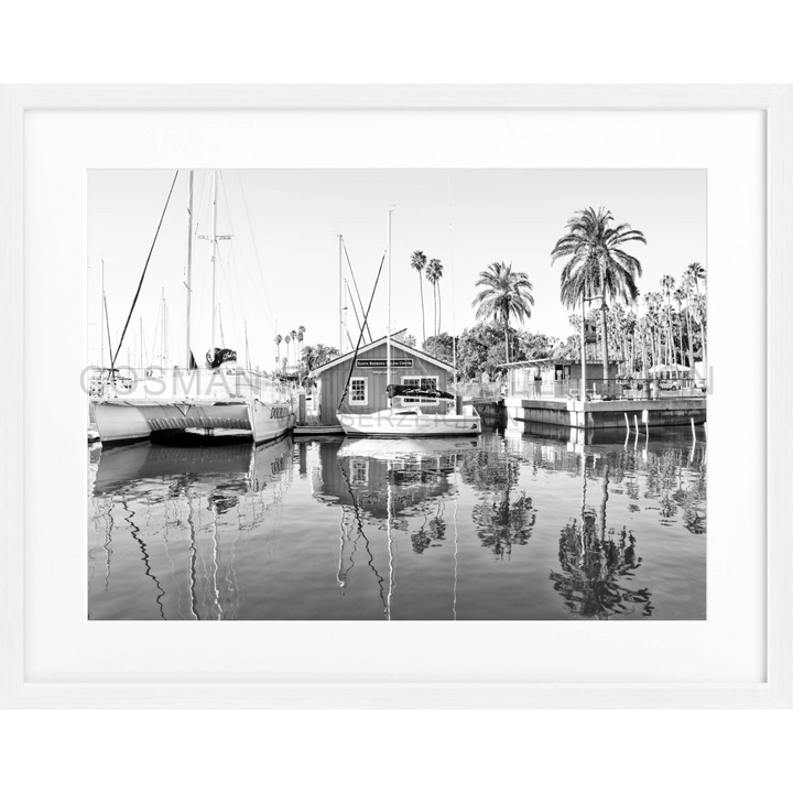 Boote und ein Bootshaus spiegeln sich im ruhigen Wasser der Santa Barbara Marina