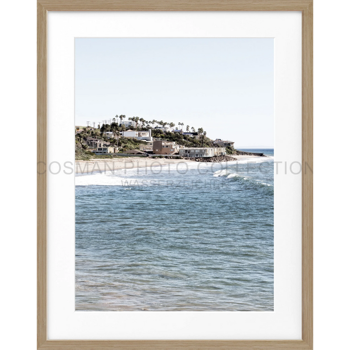 Küstenhügel mit Häusern und Palmen, Blick auf blaue Ozeanwellen in Malibu