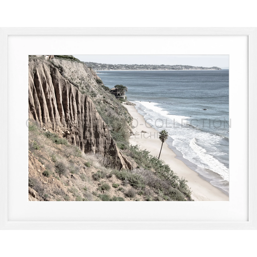 Küstenklippe mit Erosionsstreifen und Blick auf einen Sandstrand in Malibu