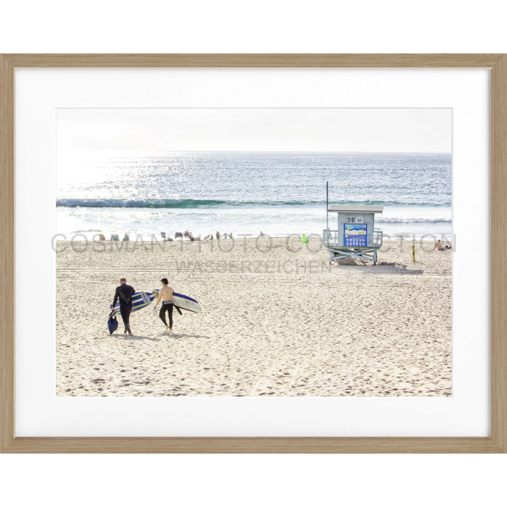 Zwei Surfer gehen mit ihren Boards über den Sandstrand von Manhattan Beach