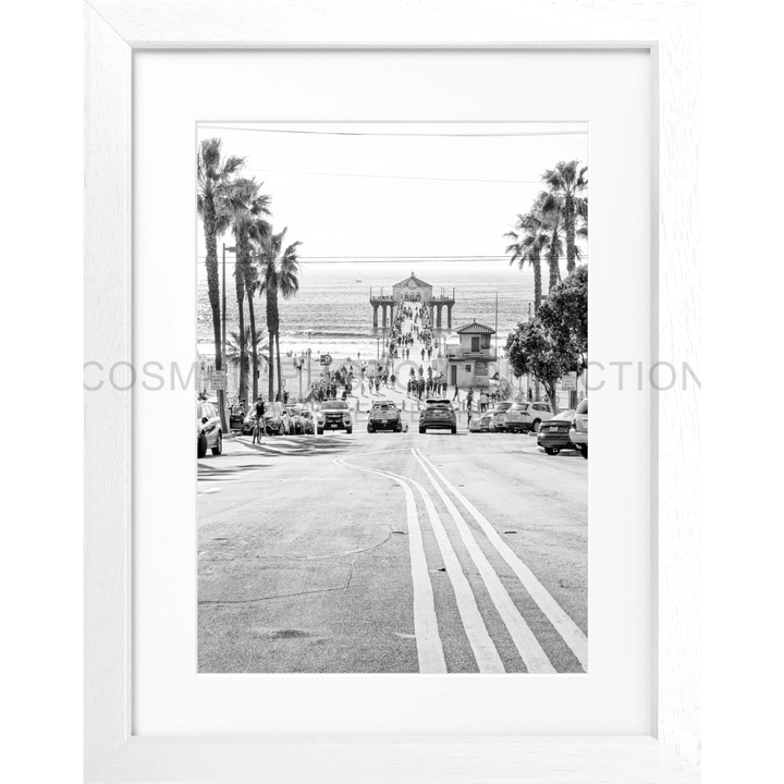 Schwarz-weiß Foto einer palmengesäumten Straße zum Küstengebäude in Manhattan Beach