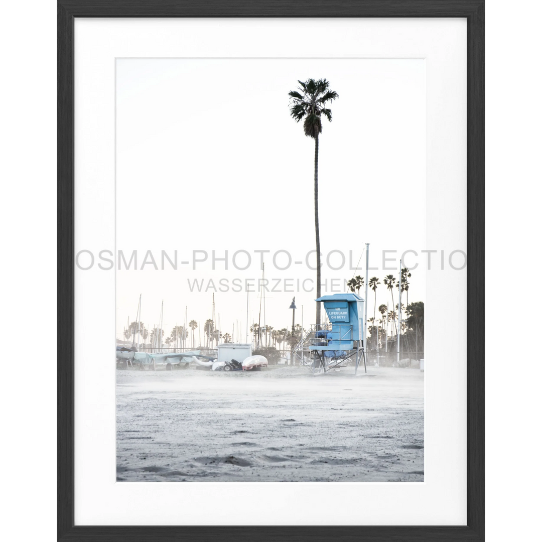 Gerahntes Schwarzweißfoto eines Rettungstrumpfs und Palmen am Strand in Santa Barbara