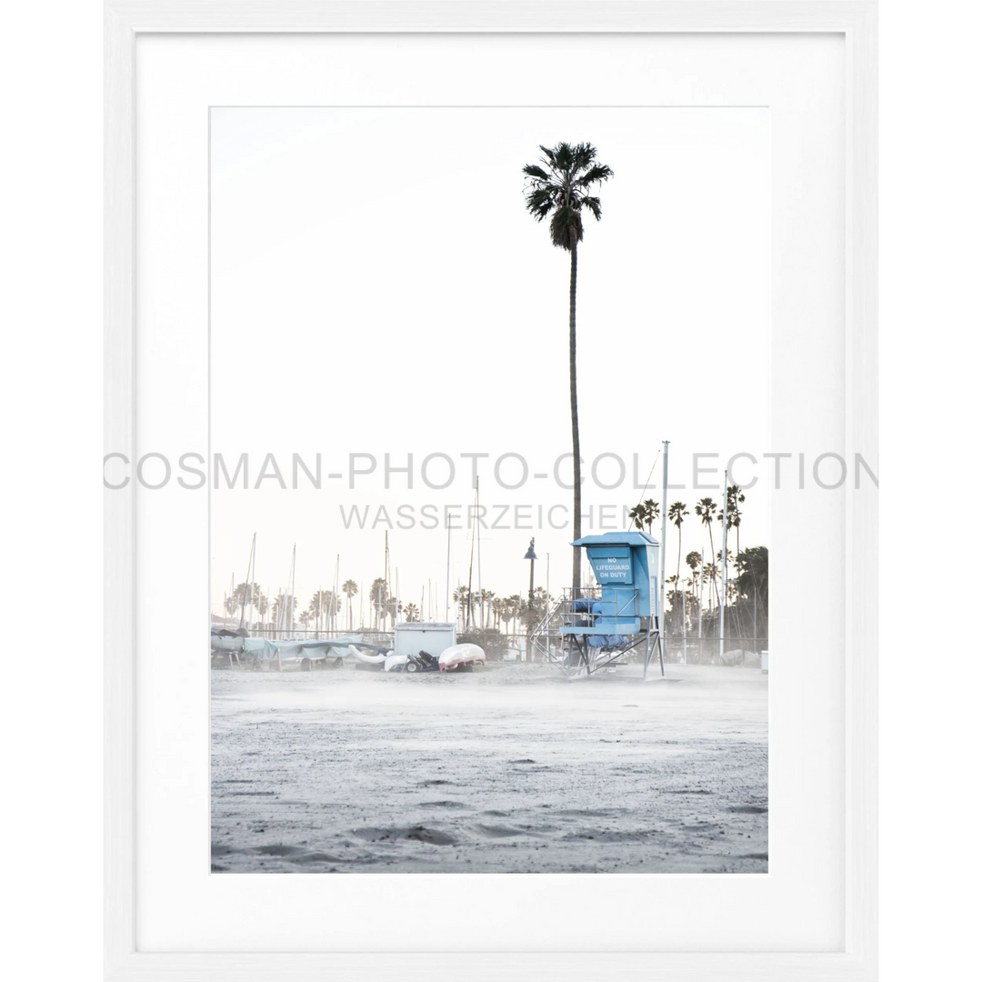 Blauer Rettungsturm mit hohen Palmen an einem nebligen Strand in Santa Barbara