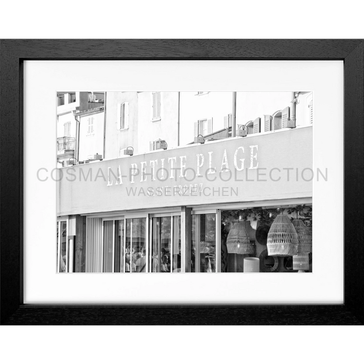 Schwarz-weißes Foto eines Geschäfts mit PETITE PLAGE Schild im Poster La Petite Plage