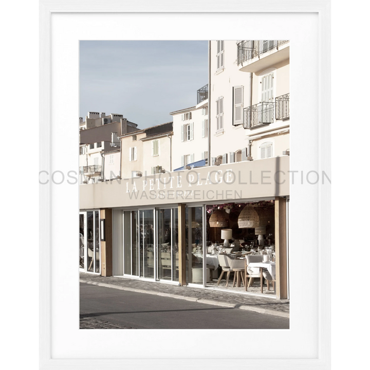 Weiß gerahmtes Poster La Petite Plage mit europäischem Straßenszenario und Café