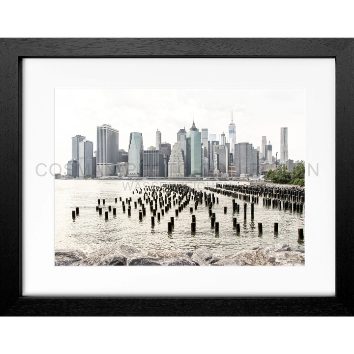 Gerahmtes Schwarz-Weiß-Foto der Manhattan Skyline mit alten Pilonen im Vordergrund