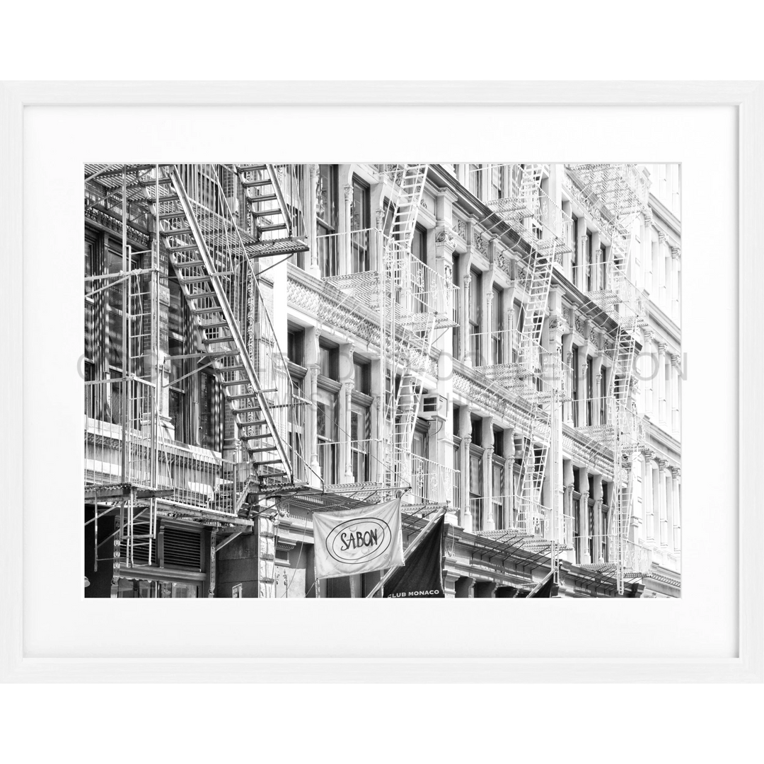 Schwarz-weiß-Fotografie von Feuerleitern an einer historischen Gebäudefassade in Soho