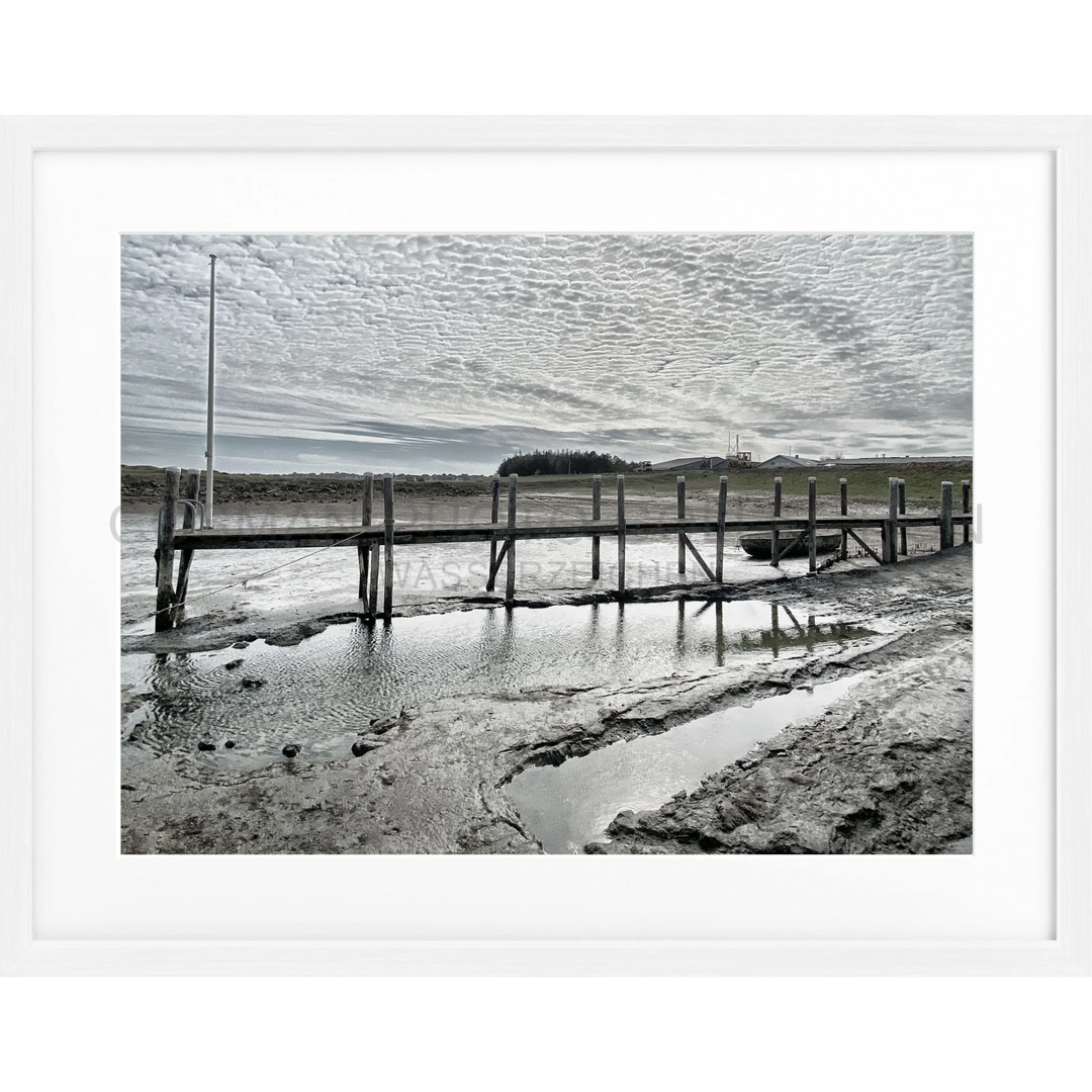 Holzpier, der sich über schlammige Gezeitenflächen im Poster Sylt Rantum Hafen SY53E erstreckt