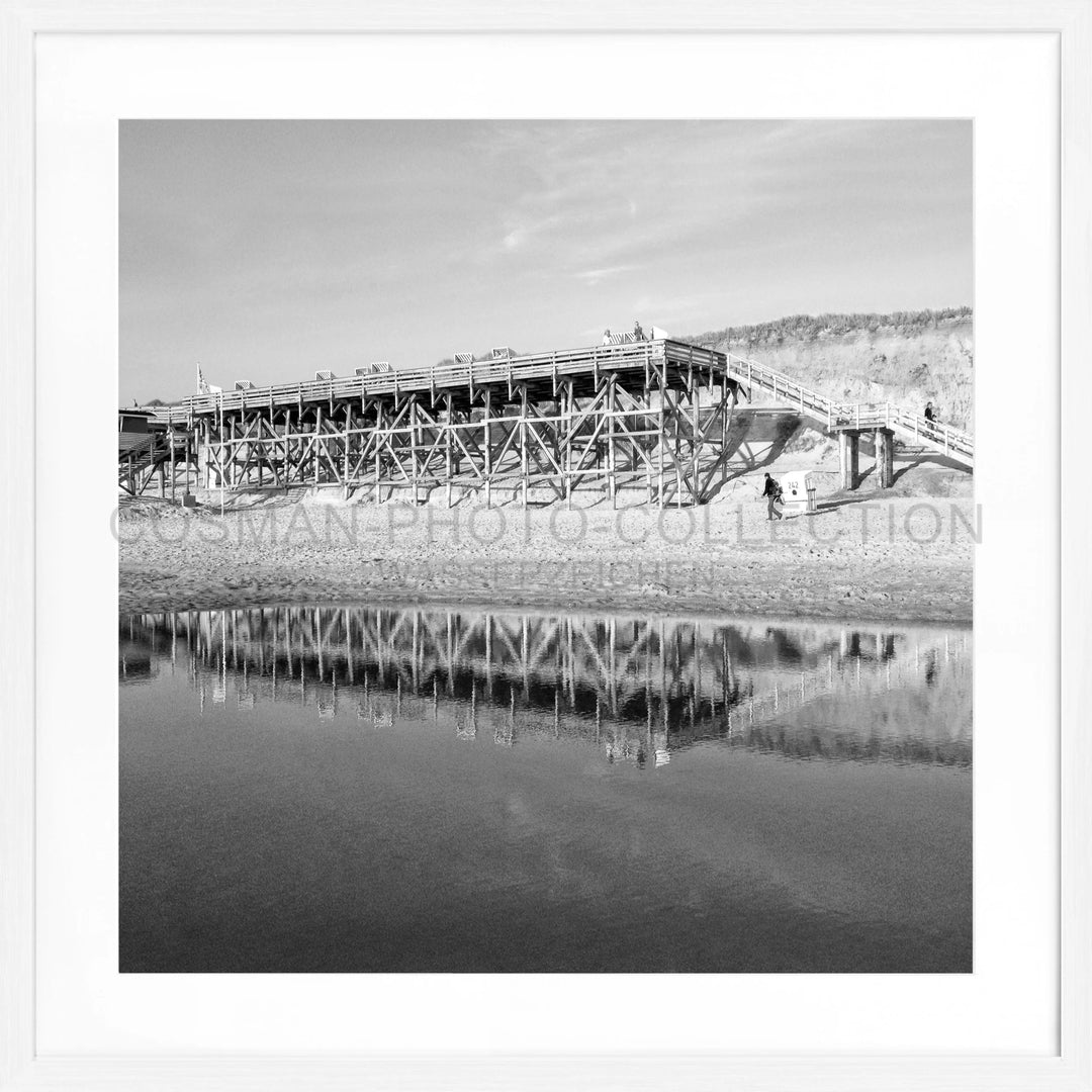 Holzstützenbrücke spiegelt sich im ruhigen Wasser, Poster Sylt Strand Kampen SY55Q