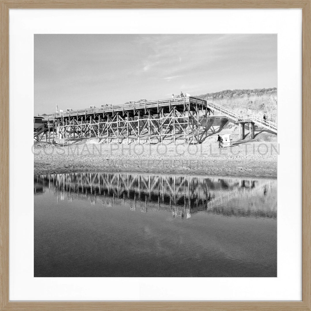 Holztrestle-Brücke spiegelt sich im ruhigen Wasser unter dem Poster Sylt Strand Kampen