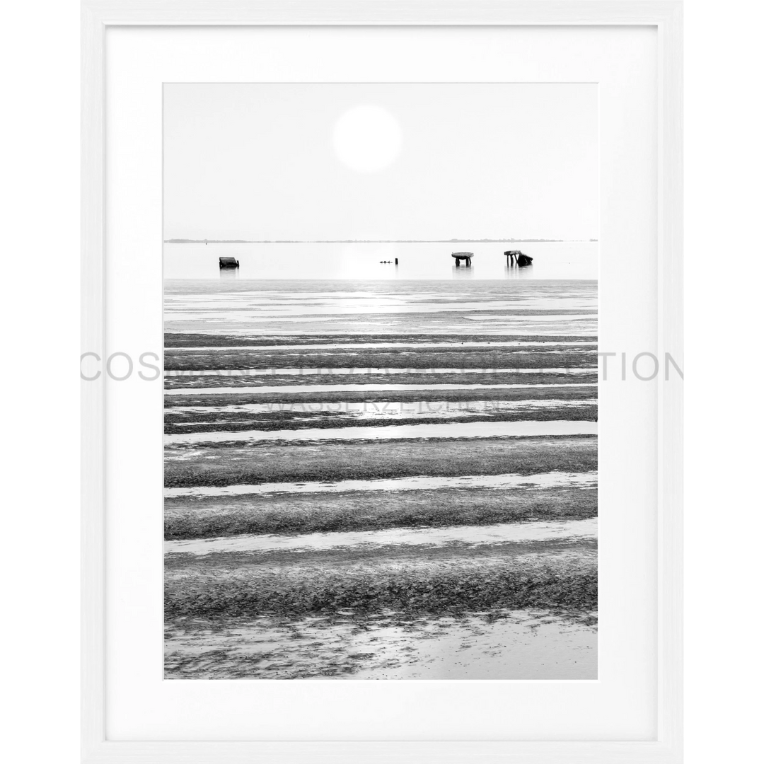 Gerippelte Sandmuster am Wattenmeer mit Strandhütten im Hintergrund